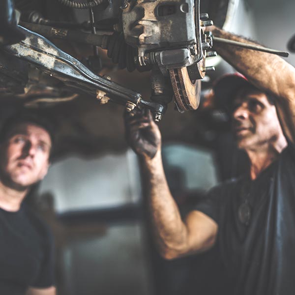 Professional mechanic repairing a car in auto repair shop Professional mechanic repairing a car in auto repair shop